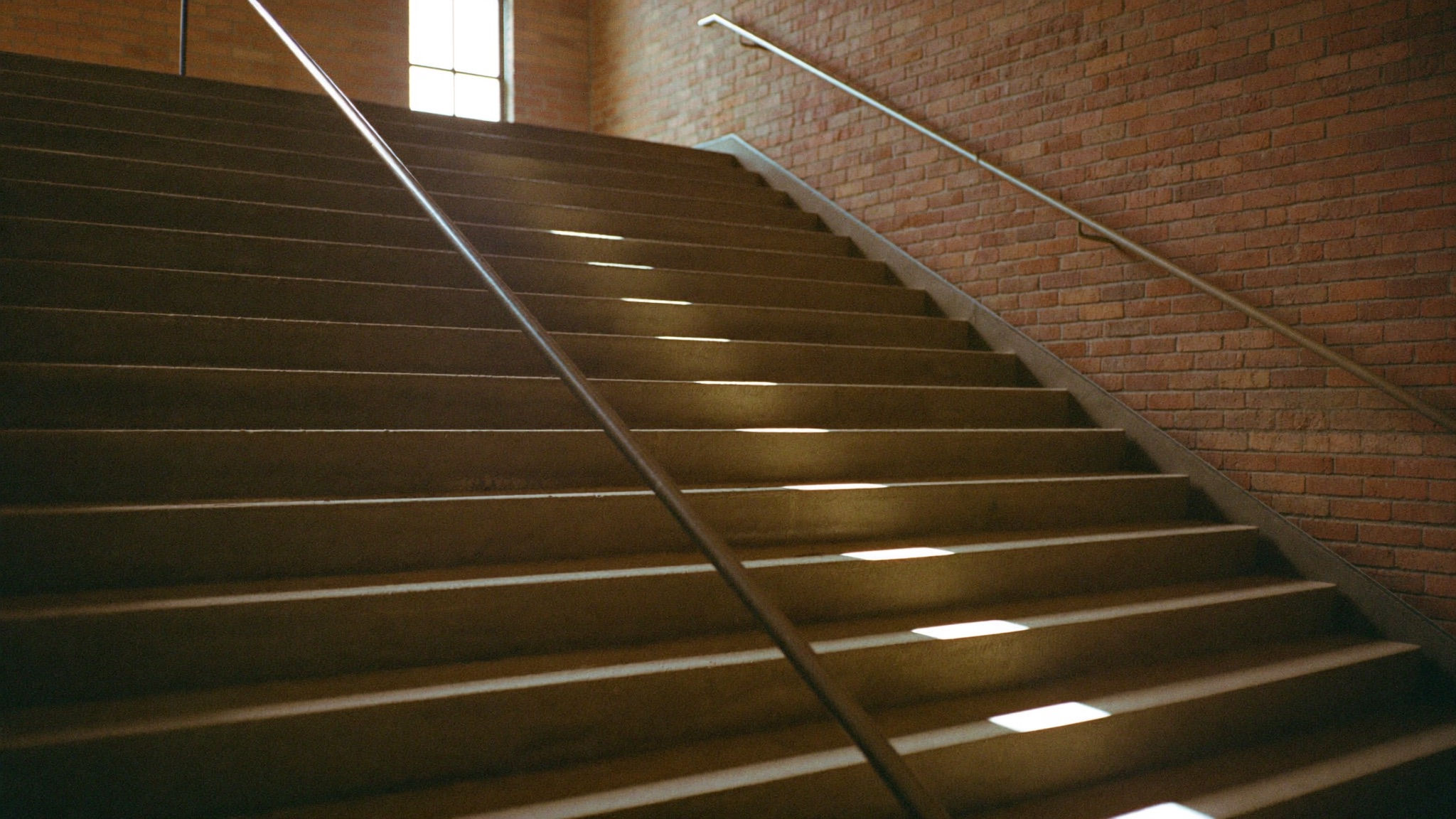 Treppenaufgang in einer umgebauten Industriehalle, das Tageslicht fällt stufenweise auf die Absätze